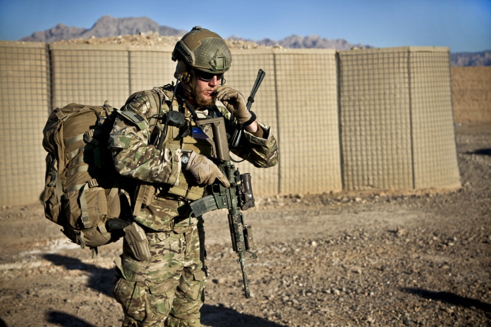 A coalition force member waits for a UH-60 Black Hawk helicopter Canvas Art - Stocktrek Images (35 x 23)