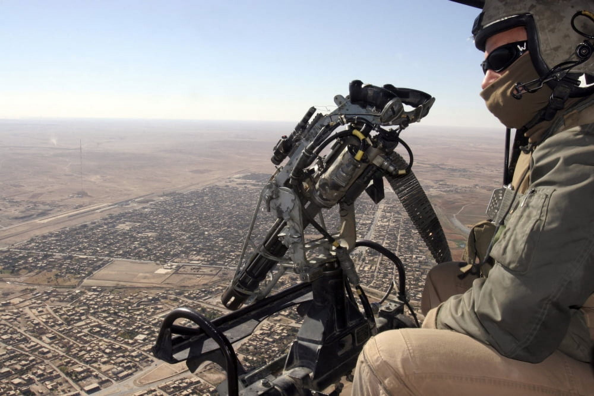 A crew chief looks for suspicious activity while manning a machine gun aboard a helicopter Canvas Art - Stocktrek Images (34 x 23)
