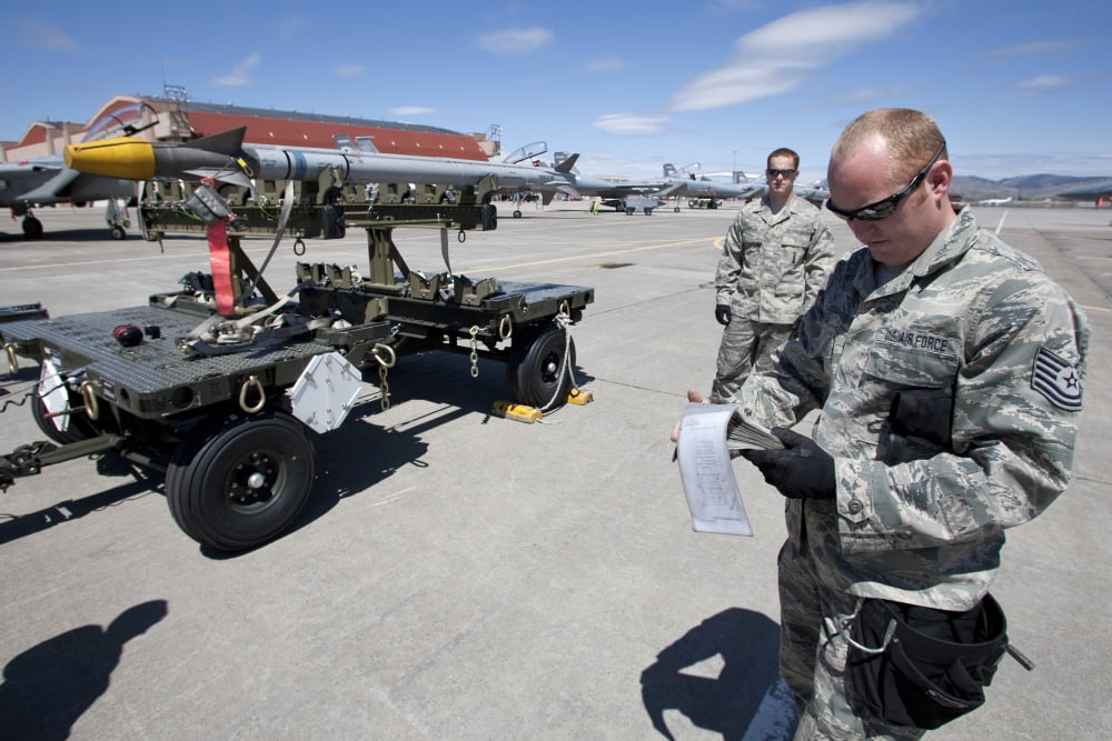 A crew chief looks over checklist as they prepare to load an AIM-9X missile Canvas Art - HIGH-G ProductionsStocktrek Images (35 x 23)