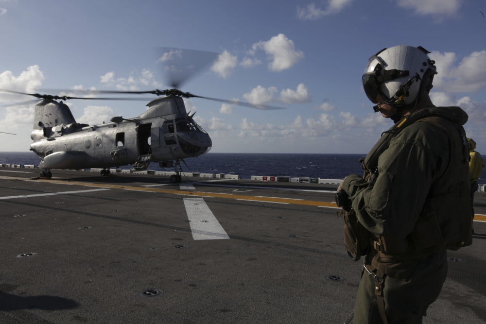 A crew chief watches a CH-46E Sea Knight helicopter aboard USS Makin Island Canvas Art - Stocktrek Images (34 x 23)