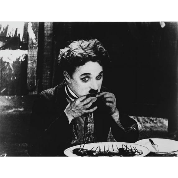 A film still of Charlie Chaplin eating Photo Print (24 x 30)