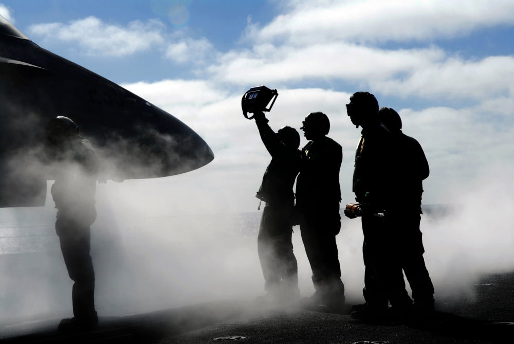 A flight deck crew member shows the pilot of an FA-18 Hornet the aircrafts weight Canvas Art - Stocktrek Images (34 x 23)