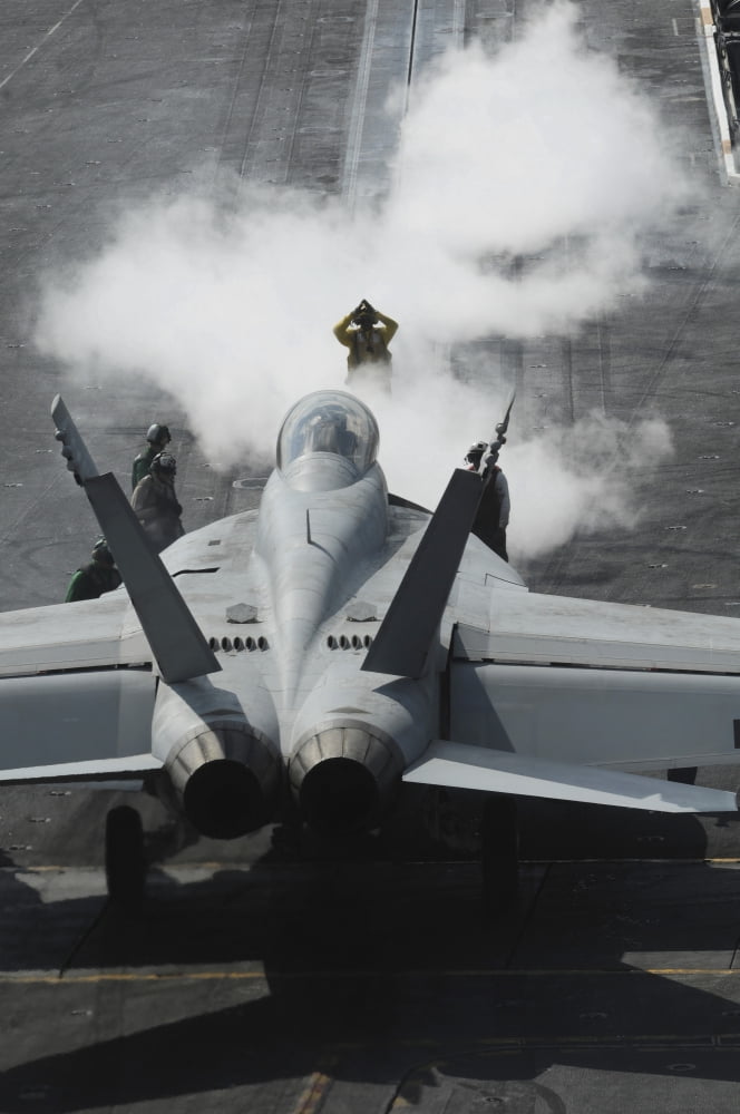 A flight deck director signals an FA-18F Super Hornet onto catapult one aboard the USS Nimitz Canvas Art - Stocktrek Images (23 x 34)