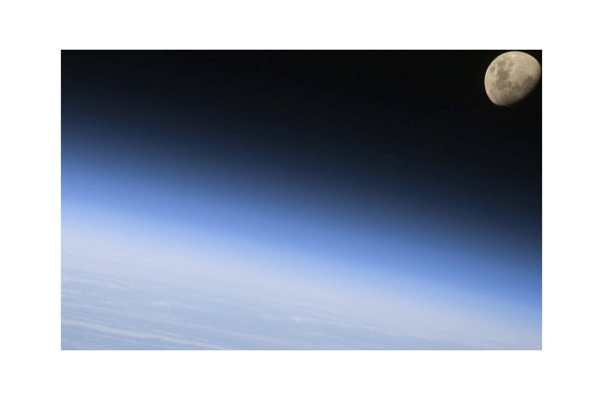 A gibbous moon visible above Earths atmosphere Canvas Art - Stocktrek Images (34 x 23)
