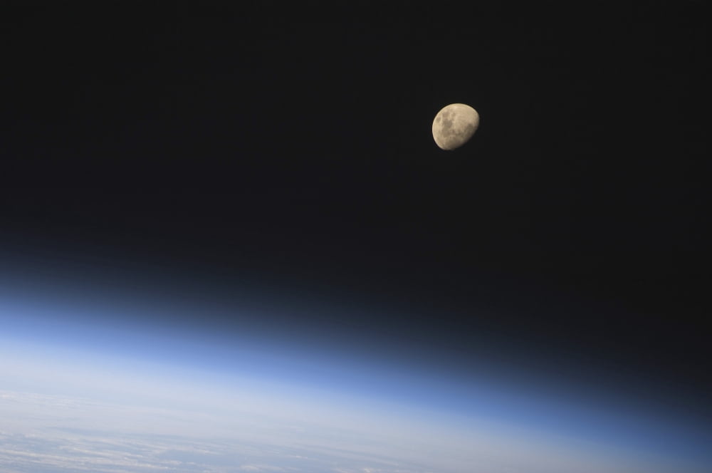 A gibbous moon visible above Earths atmosphere Canvas Art - Stocktrek Images (34 x 23)