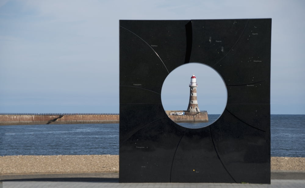 A lighthouse viewed through a round hole in a black sculpture Sunderland Tyne and Wear England Canvas Art - John Short Design Pics (38 x 24)
