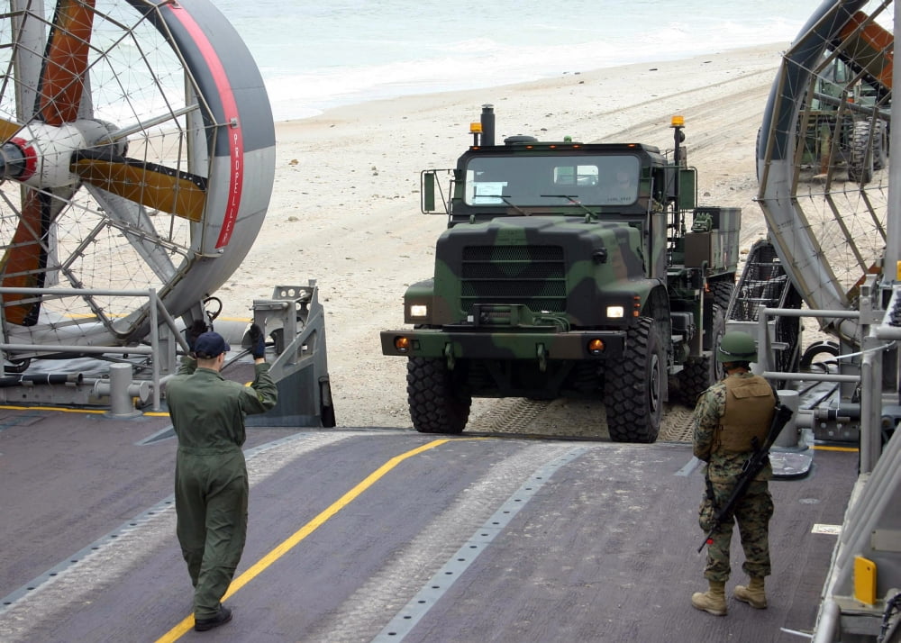 A loadmaster guides a Marine 7-ton truck onto his Landing Craft Air Cushioned Canvas Art - Stocktrek Images (33 x 23)