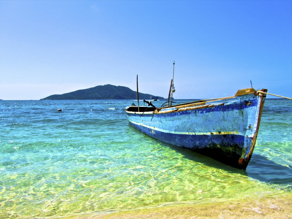 A lone boat on the shore of Cayos Cochinos Honduras Canvas Art - Amanda NichollsStocktrek Images (16 x 12)