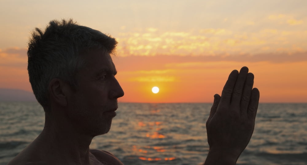 A man in prayer or yoga pose as the sun set on a tropical beachPuerto vallarta mexico Canvas Art - Debra Brash Design Pics (21 x 11)