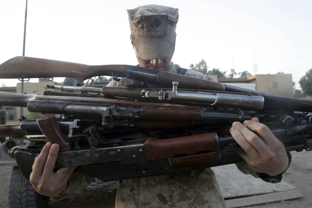 A marine readies 80 pounds of enemy rifles seized Canvas Art - Stocktrek Images (34 x 23)