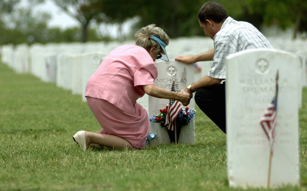 A mother and her son hold hands and pray at a grave site Canvas Art - Stocktrek Images (35 x 22)