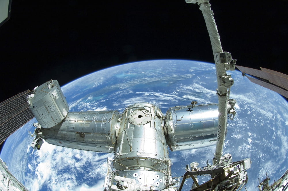 A portion of the International Space Station against Earths horizon Canvas Art - Stocktrek Images (35 x 23)
