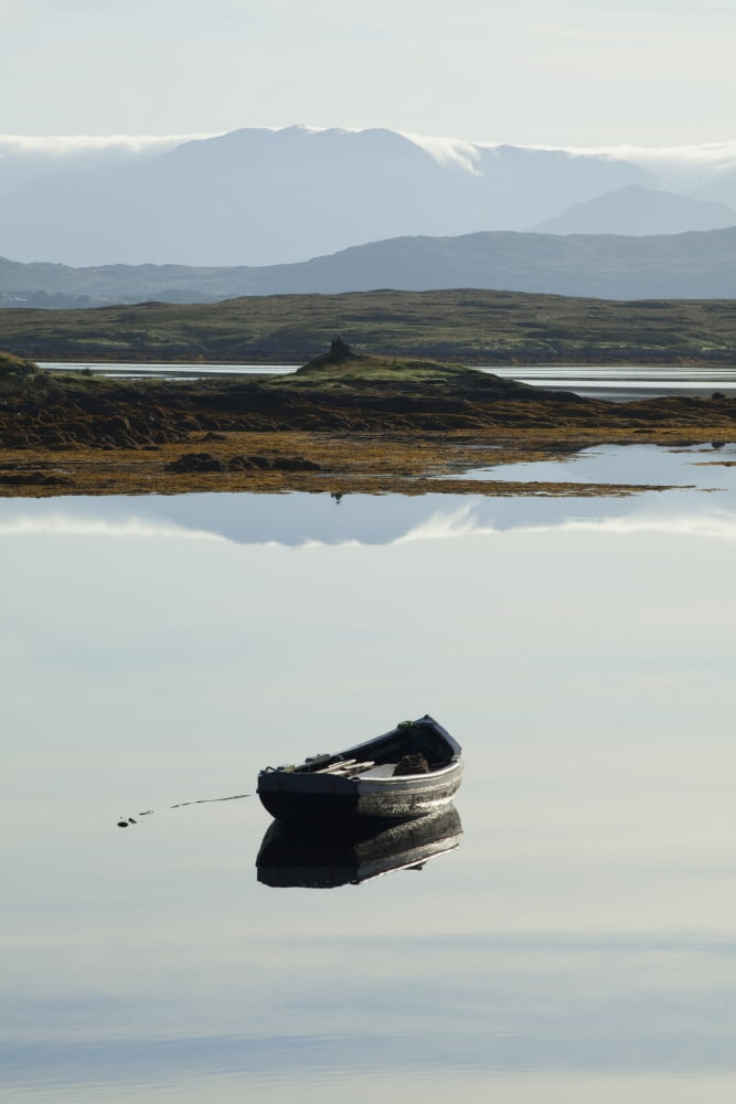 A rowboat sits in a tranquil lake with hills in the background near roundstoneCounty galway ireland Canvas Art - Peter Zoeller Design Pics (24 x 38)