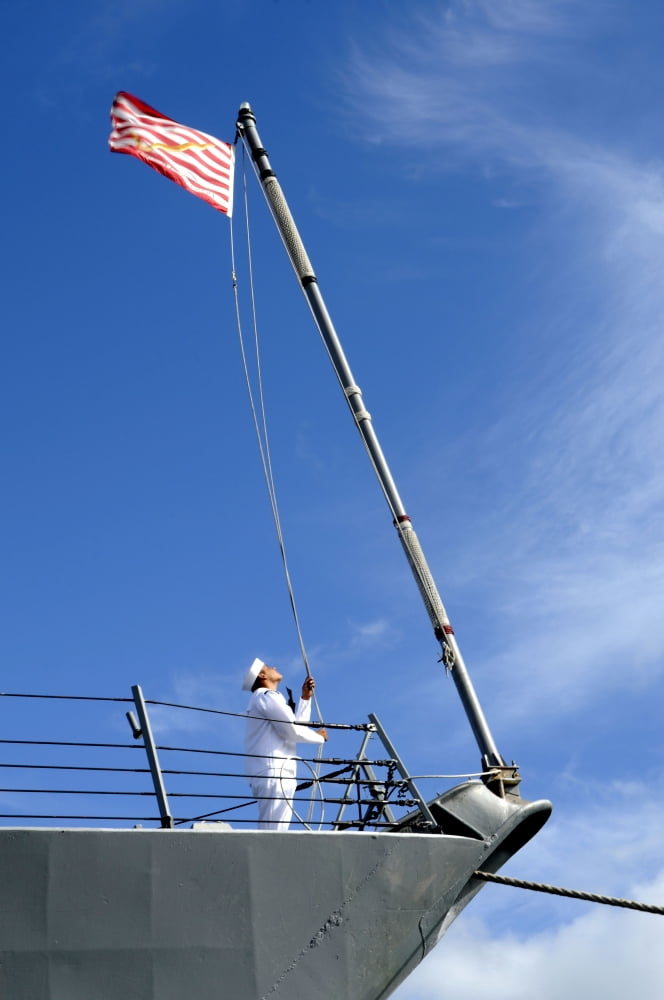 A sailor lowers the US Navy Jack aboard USS Chafee Canvas Art - Stocktrek Images (23 x 35)