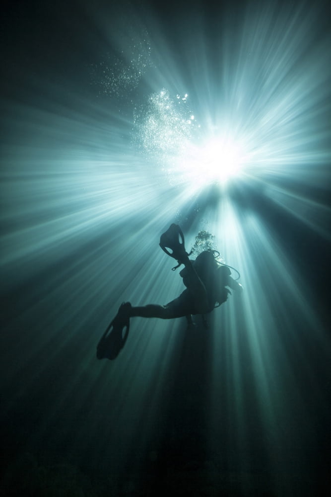 A scuba diver ascends into the light emanating above Canvas Art - Michael WoodStocktrek Images (23 x 35)