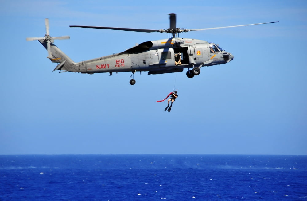 A search and rescue swimmer is lowered from an SH-60F Sea Hawk helicopter Canvas Art - Stocktrek Images (35 x 23)