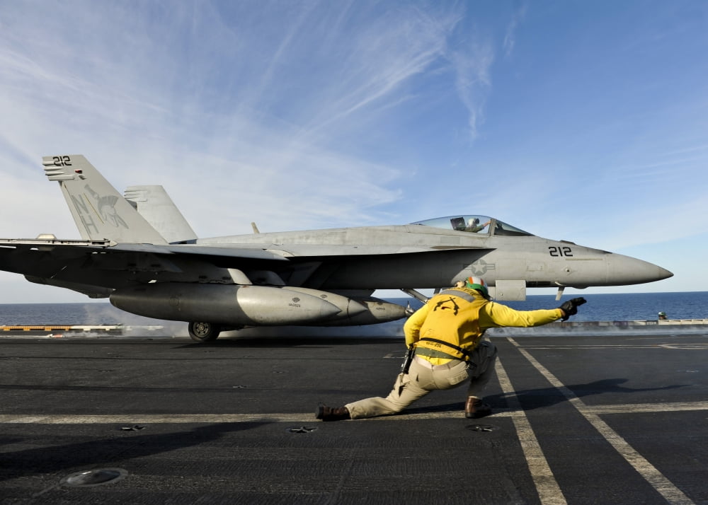 A shooter signals to launch an FA-18E Super Hornet aboard USS Nimitz Canvas Art - Stocktrek Images (34 x 24)