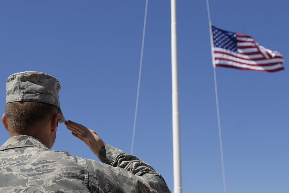 A soldier salutes the American Flag Canvas Art - Stocktrek Images (35 x 23)