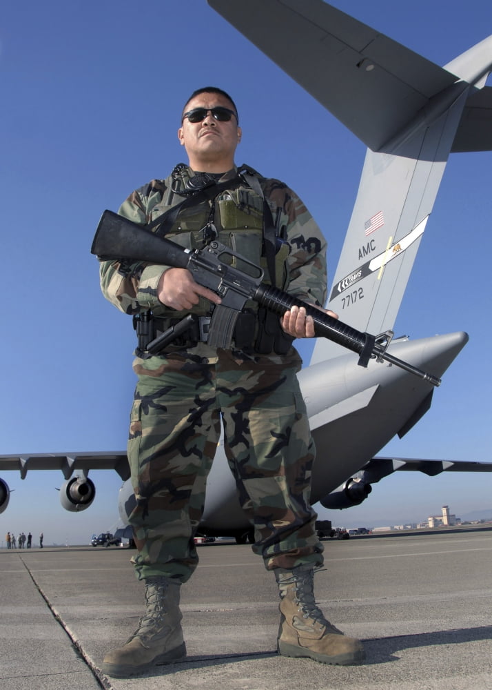 A soldier scans stands guard close to the secured perimeter of a C-17 Globemaster III Canvas Art - Stocktrek Images (24 x 34)