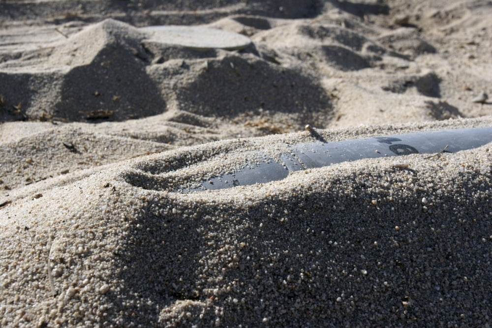 A static display of an ordnance shell and a mine lay half-buried in the sand Canvas Art - Stocktrek Images (34 x 23)
