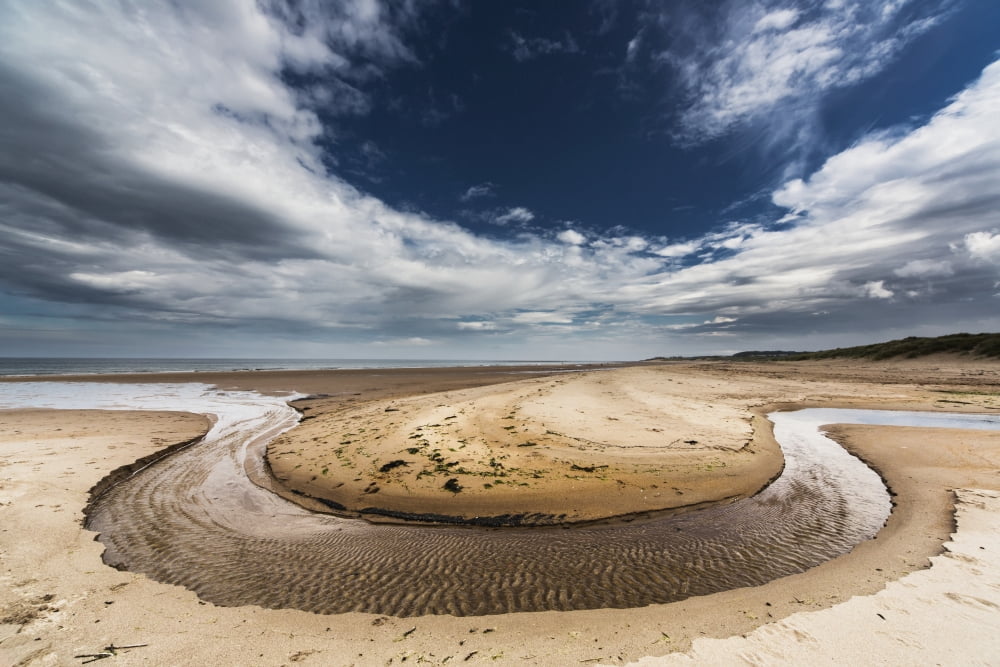 A stream formed in a circular shape in the sand along the coastDruridge bay northumberland england Canvas Art - John Short Design Pics (38 x 24)