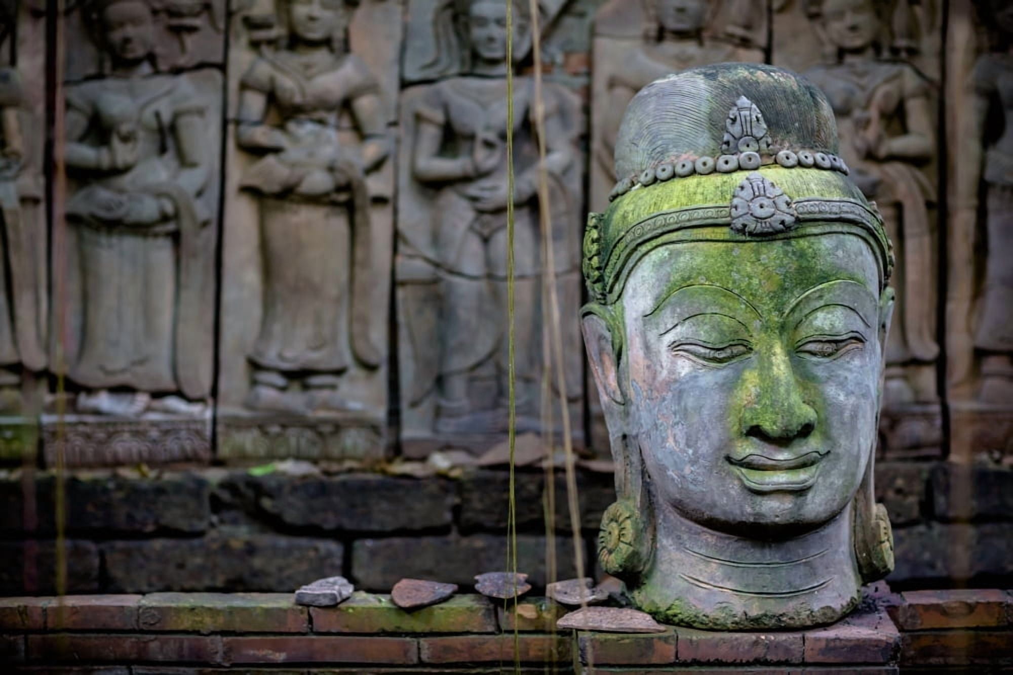 A terra cotta head of buddha sits in front of bas-relief in a terra cotta garden Chiang Mai Thailand Canvas Art - Matt Brandon Design Pics (19 x 12)