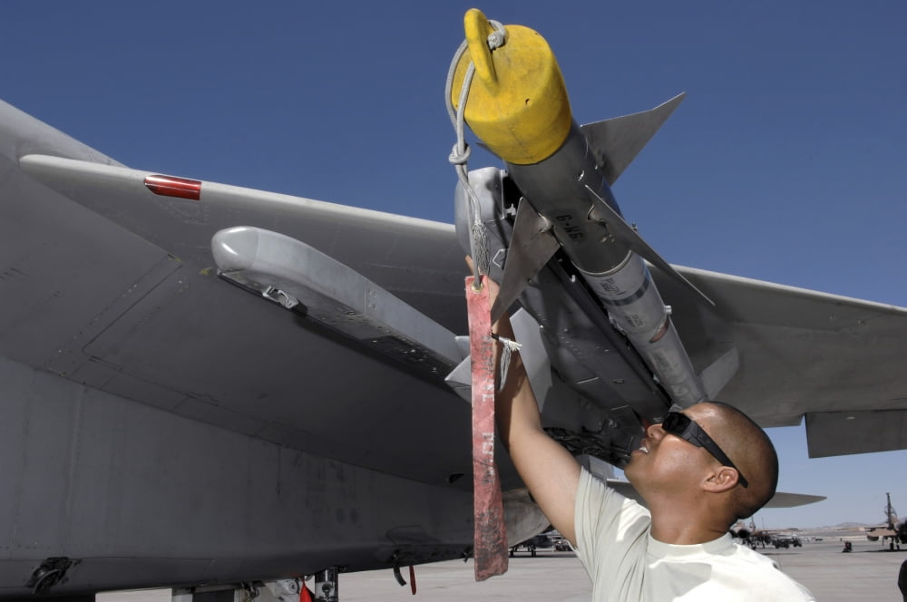 A weapons expediter inspects an AIM-9 missile on a F-15 aircraft Canvas Art - Stocktrek Images (34 x 23)