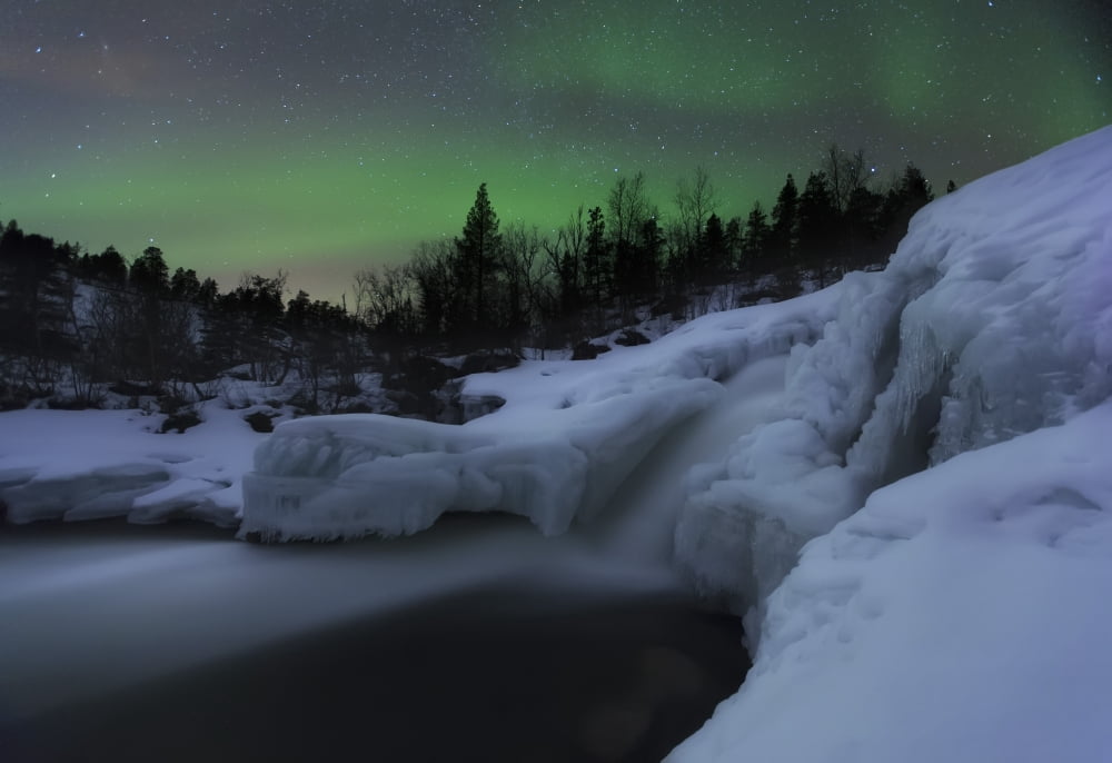 A wintery waterfall and aurora borealis over Tennevik River Norway Canvas Art - Arild HeitmannStocktrek Images (17 x 12)