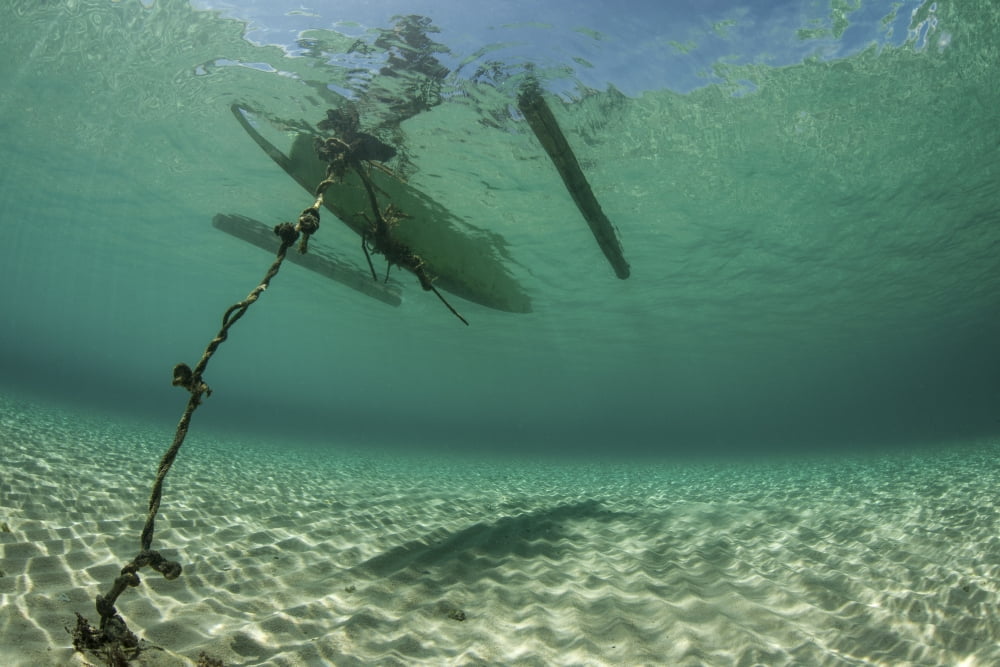 A wooden outrigger anchored near a remote island in Indonesia Canvas Art - Ethan DanielsStocktrek Images (34 x 23)