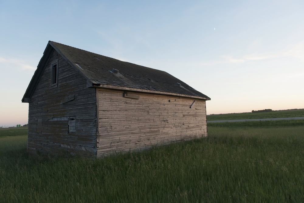A wooden shed in the middle of a grass field Canvas Art - Keith Levit Design Pics (19 x 12)