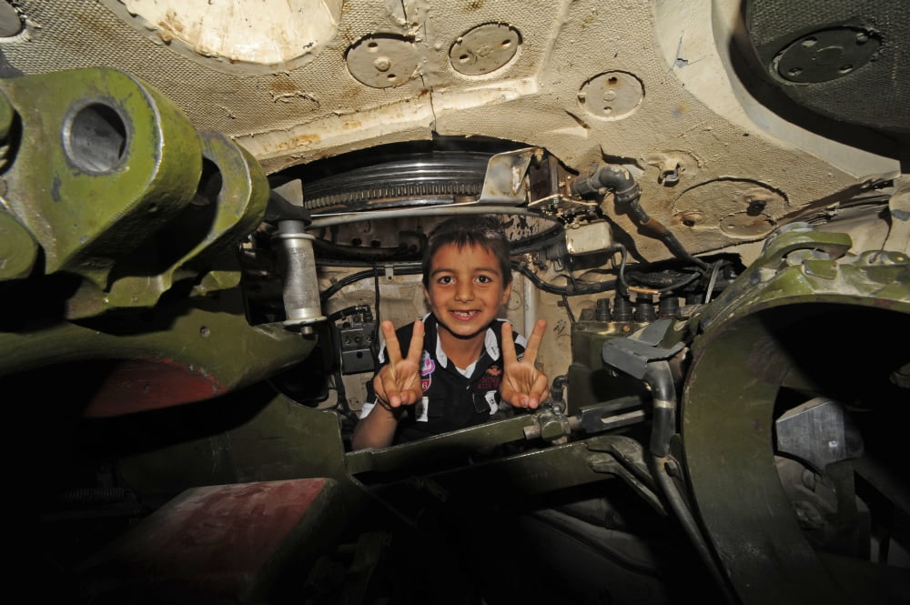 A young Syrian boy sitting inside of a T-72 main battle tank Canvas Art - Andrew ChittockStocktrek Images (35 x 23)