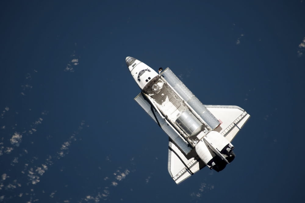 Aerial view of Space Shuttle Discovery over Earth as it approaches the International Space Station Canvas Art - Stocktrek Images (34 x 23)