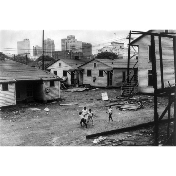 African American Children Playing In Slum In View Of High Rise Buildings In Background. North Carolina History