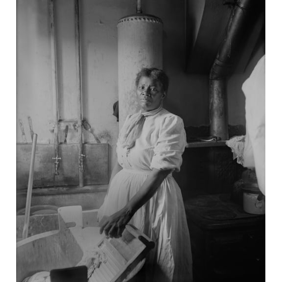 African American Woman Standing By A Washtub With Her Hand On A Washboard. Ca. 1920. History