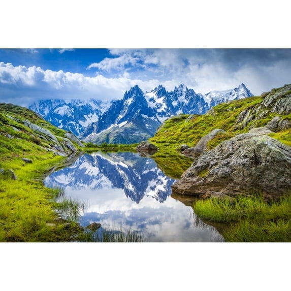 Aiguille des Charmoz part of Aiguilles de Chamonix reflects on Lac Flegere surrounded with green meadow Aiguilles Rouges;
