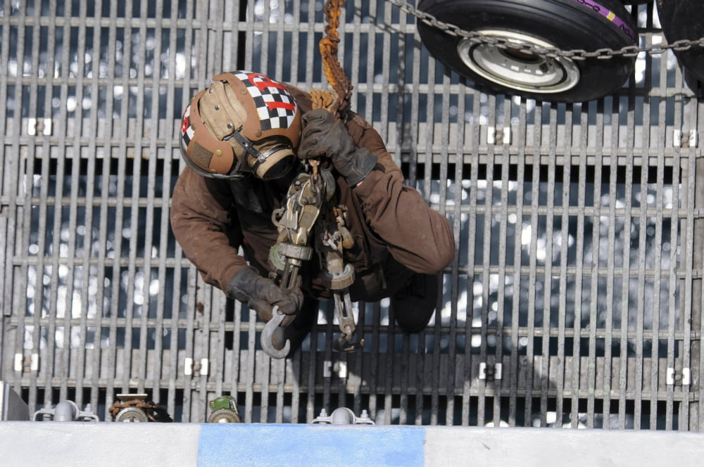 Airman carries chains to the flight deck aboard USS George HW Bush Canvas Art - Stocktrek Images (35 x 23)