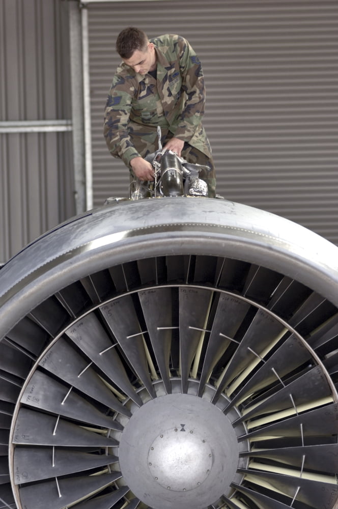 Airman checks components atop a C-5 Galaxy turbofan engine Canvas Art - Stocktrek Images (23 x 35)