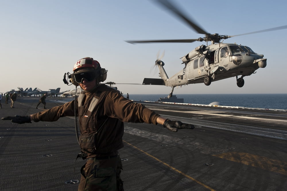 Airman checks for a clear deck as an MH-60S Sea Hawk takes off USS John C Stennis Canvas Art - Stocktrek Images (35 x 23)