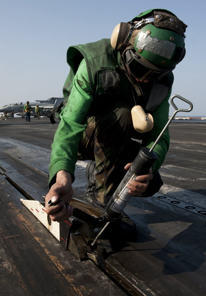 Airman greases the catapult shuttle on USS John C Stennis Canvas Art - Stocktrek Images (24 x 34)