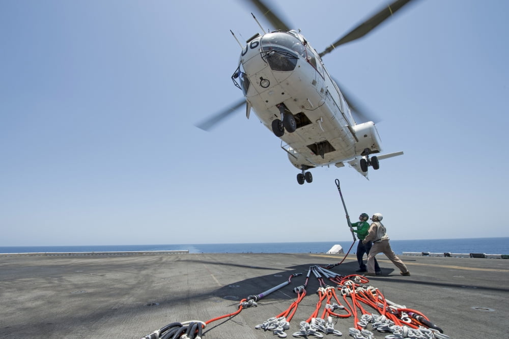 Airmen attach a cargo hook to an SA-330J Puma helicopter Canvas Art - Stocktrek Images (34 x 23)