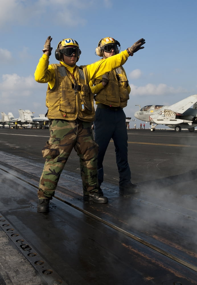 Airmen direct an FA-18C Hornet on the flight deck of USS John C Stennis Canvas Art - Stocktrek Images (24 x 34)