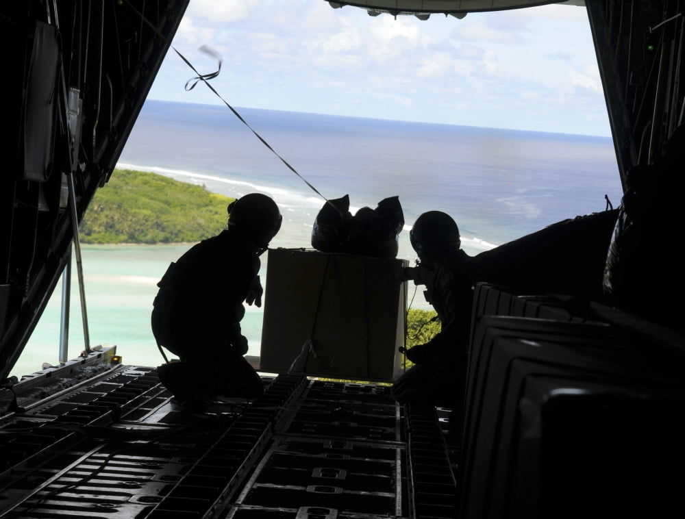 Airmen push out a pallet of donated goods from a C-130 Hercules Canvas Art - Stocktrek Images (32 x 25)