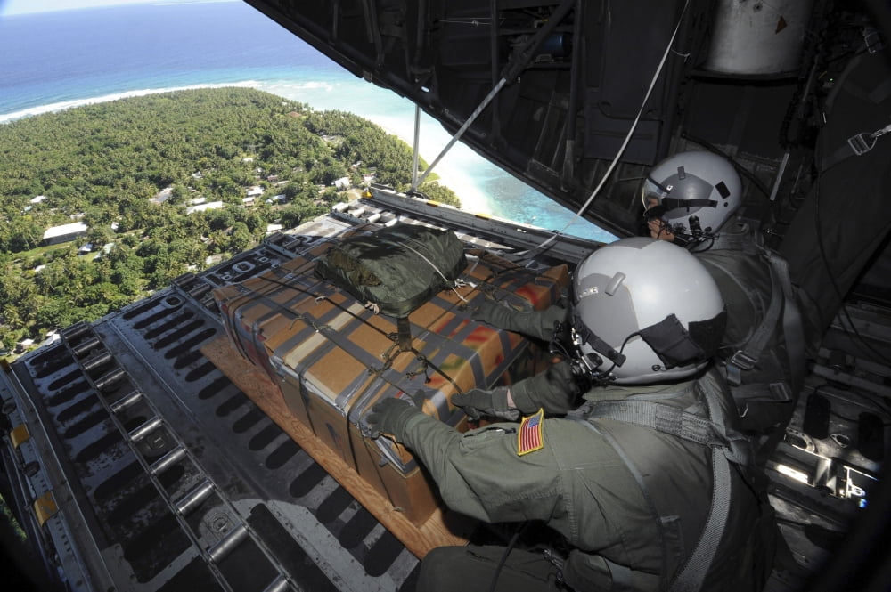 Airmen push out a pallet of donated goods over the Island of Yap from a C-130 Hercules Canvas Art - Stocktrek Images (35 x 23)