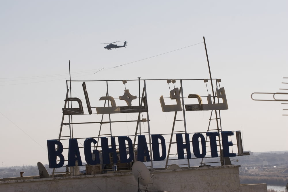 An AH-64 Apache in flight over the Baghdad Hotel in central Baghdad Iraq Canvas Art - Terry MooreStocktrek Images (18 x 12)