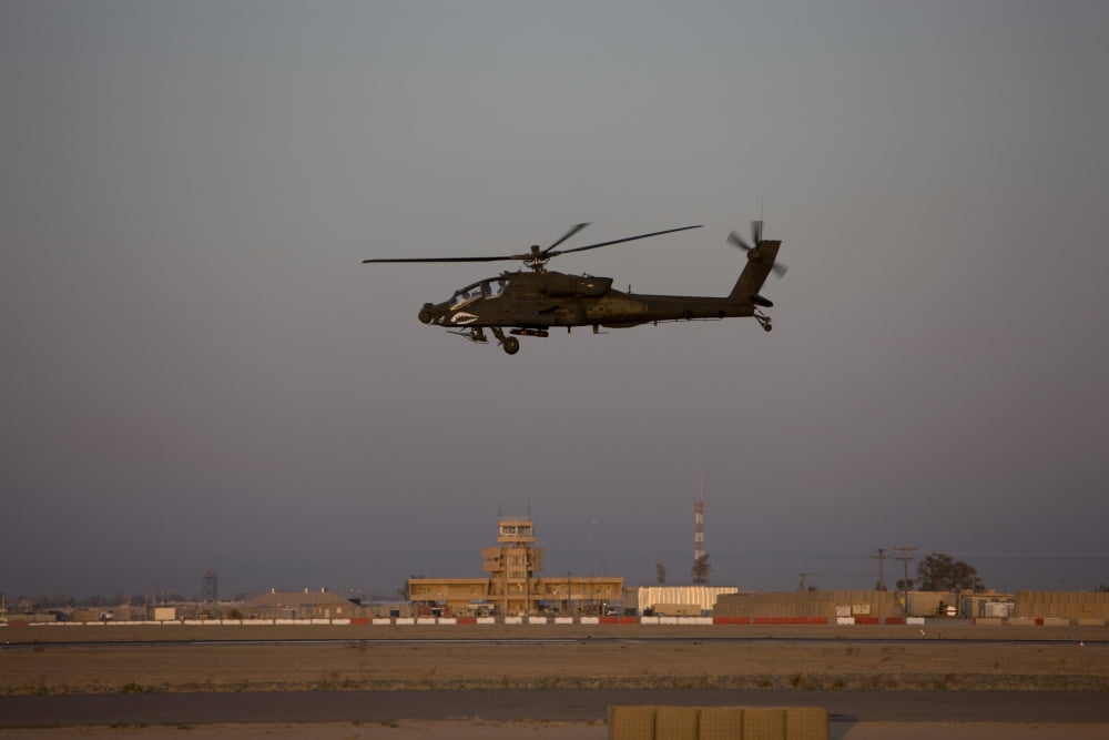 An AH-64D Apache Longbow Block III flies by the control tower on Camp Speicher Canvas Art - Terry MooreStocktrek Images (18 x 12)