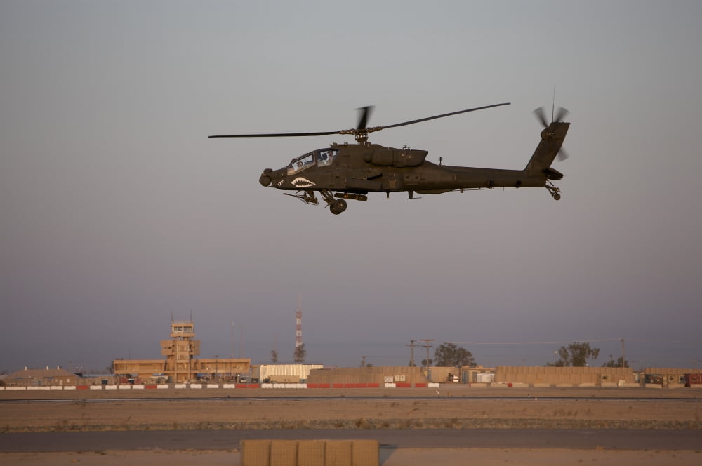 An AH-64D Apache Longbow Block III flies by the control tower on Camp Speicher Canvas Art - Terry MooreStocktrek Images (35 x 23)