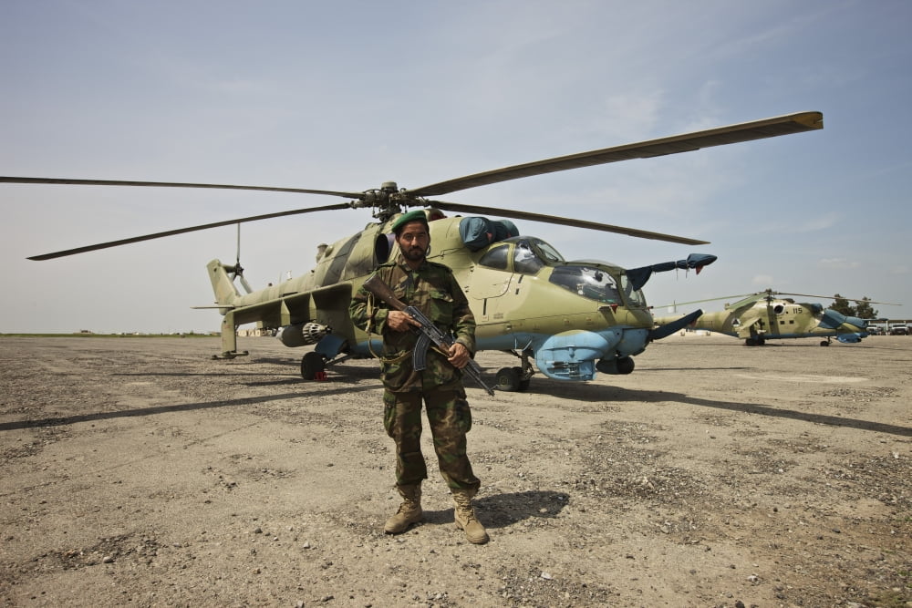 An Afghan Army soldier guards a couple Mi-35 attack helicopters Canvas Art - Terry MooreStocktrek Images (18 x 12)