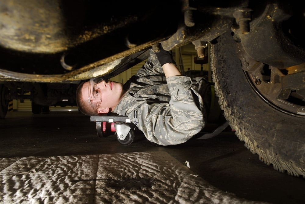 An Airman inspects the undercarriage of an F-350 truck Canvas Art - Stocktrek Images (34 x 23)