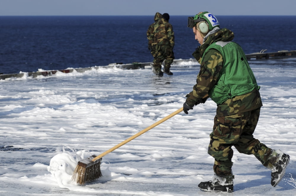 An Airman scrubs the flight deck aboard the aircraft carrier USS Ronald Reagan Canvas Art - Stocktrek Images (34 x 23)