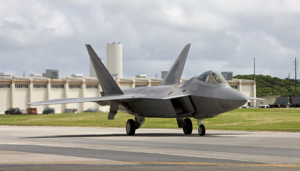 An F-22 Raptor taxis to the end of runway at Kadena Air Base Japan Canvas Art - HIGH-G ProductionsStocktrek Images (38 x 22)